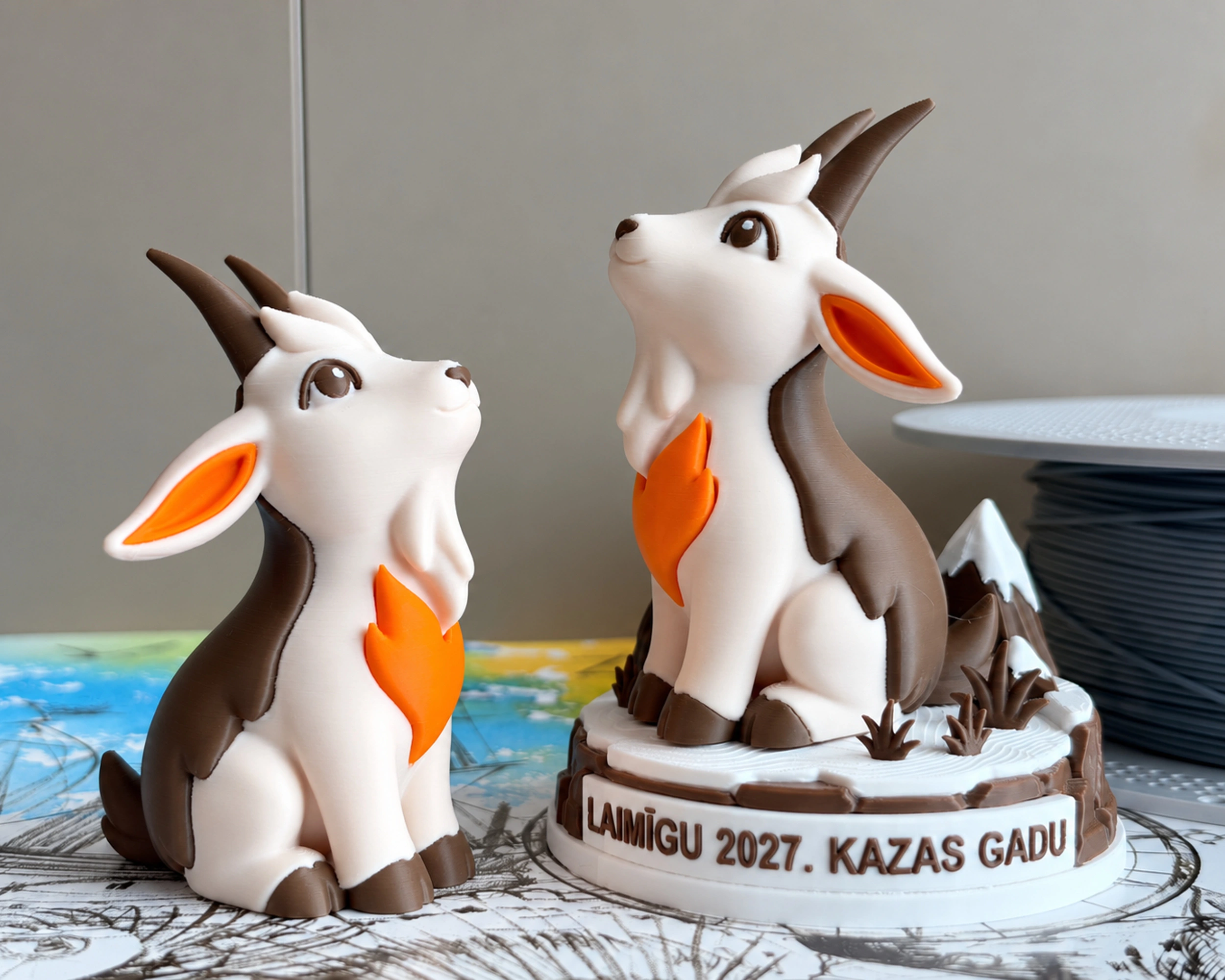 Set of two goat figurines: one without a base and one on a festive base with the Latvian inscription LAIMĪGU 2027. KAZAS GADU.